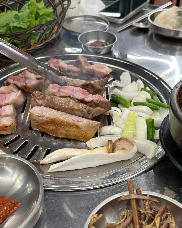 불판 위에서 맛있게 익어가는 흑돼지 오겹살