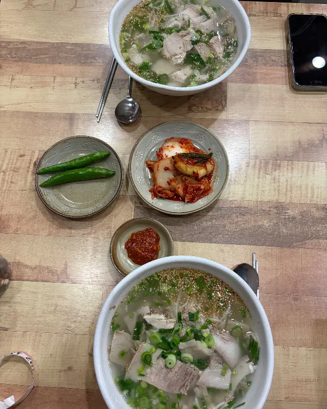 테이블 위에 놓인 고기국수와 김치, 고추