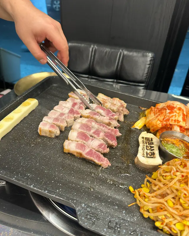 불판 위에서 먹기 좋게 잘린 흑돼지 오겹살