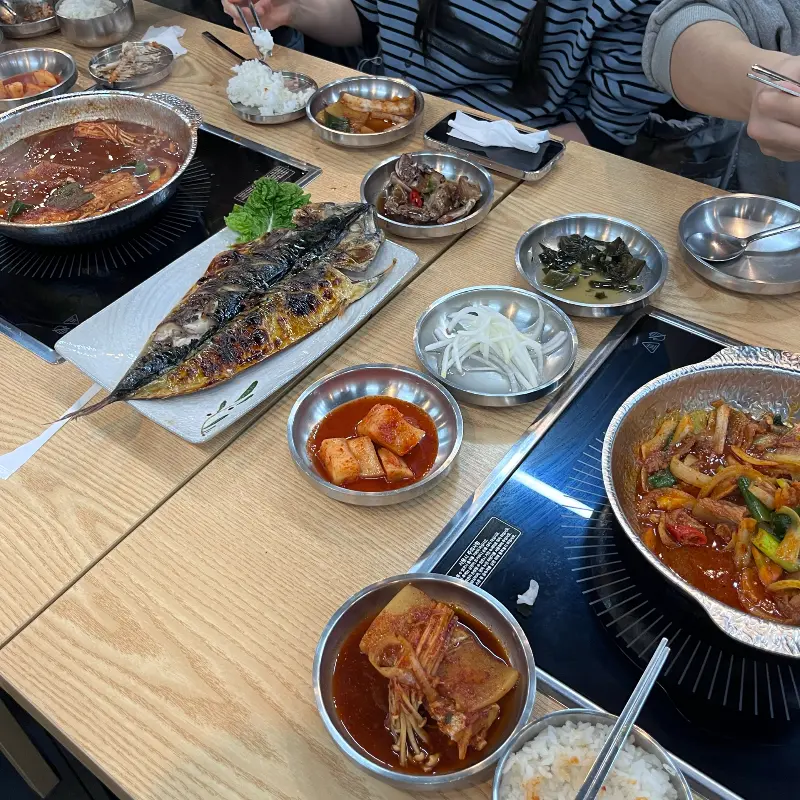 고등어 김치찜과 고등어 구이, 각종 반찬이 가득한 식탁