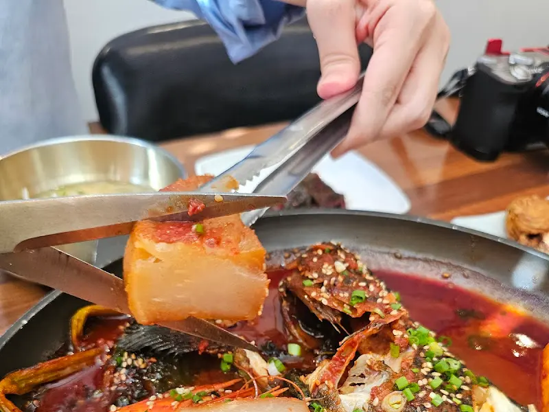 우럭조림에 들어간 무를 집게로 자르는 모습