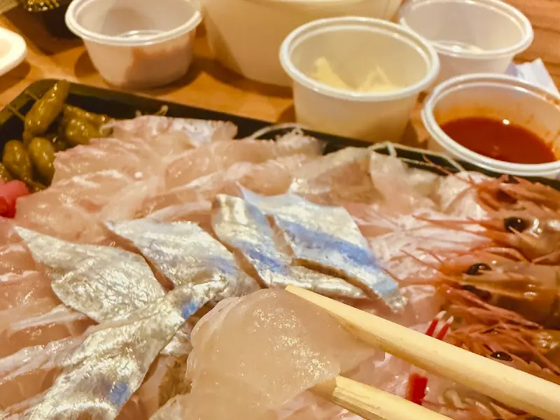 신선한 회를 젓가락으로 들어 올리는 모습