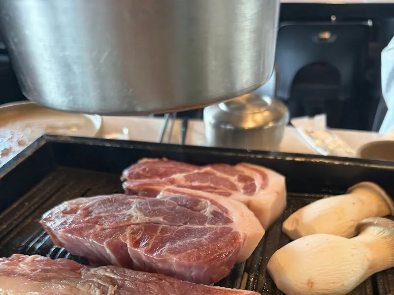 불판 위에서 구워지고 있는 두툼한 흑돼지 목살