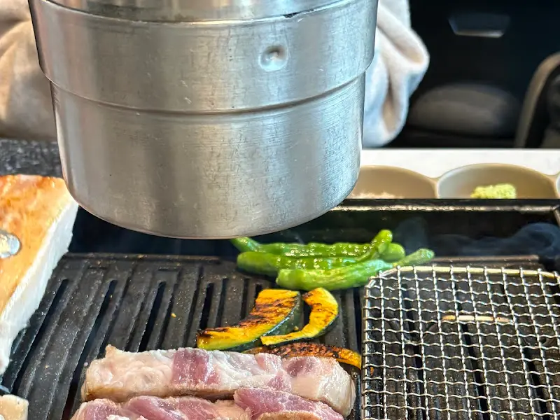 작산 애월점의 불판 위에 놓인 흑돼지 삼겹살과 목살