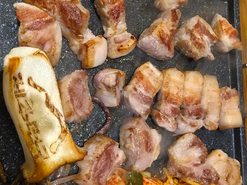 노릇하게 구워진 오겹살과 큼지막한 새송이버섯