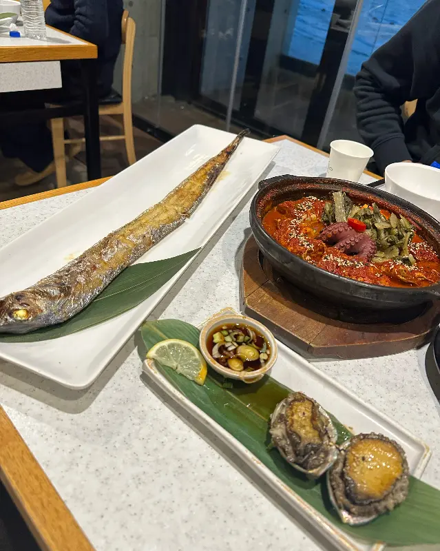 갈치구이, 갈치조림, 전복구이가 테이블 위에 놓여진 모습. 갈치구이의 압도적인 길이와 갈치조림의 매콤한 비주얼이 인상적이다.