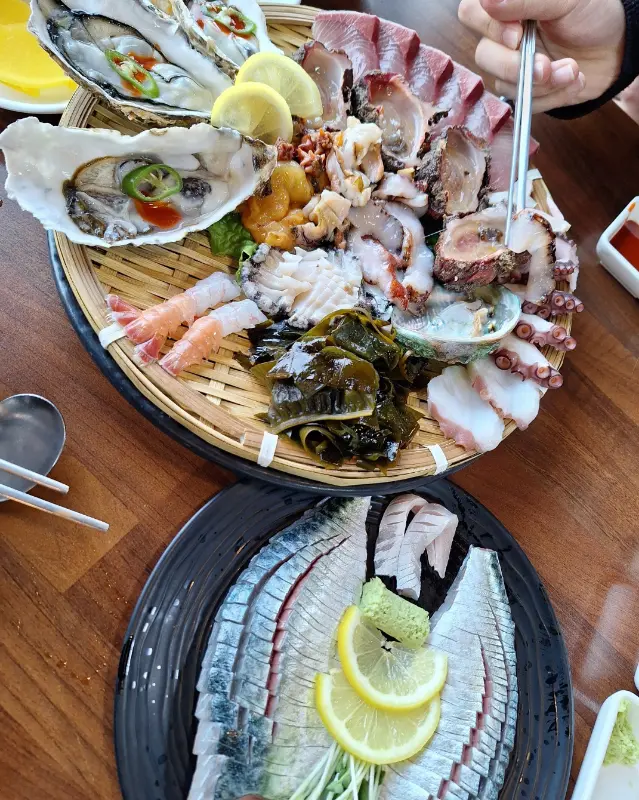 해산물 모듬과 고등어회 세트가 푸짐하게 차려진 모습