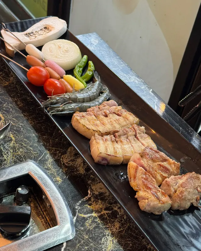 맛있게 구워진 흑돼지 오겹살을 명이나물에 싸 먹는 모습