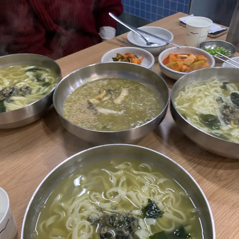 테이블 위에 놓인 보말칼국수와 반찬들