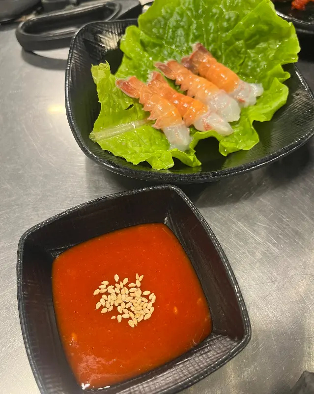 초벌된 흑돼지 근고기와 왕새송이버섯이 나무 도마에 담겨져 있다.