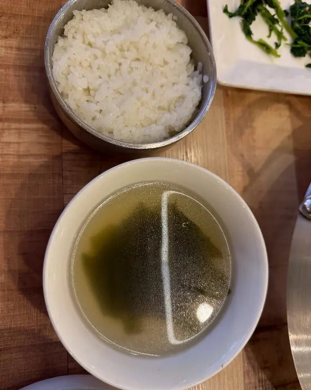 밥과 미역국이 담긴 그릇. 따뜻한 흰 쌀밥과 시원한 미역국이 조화롭다.