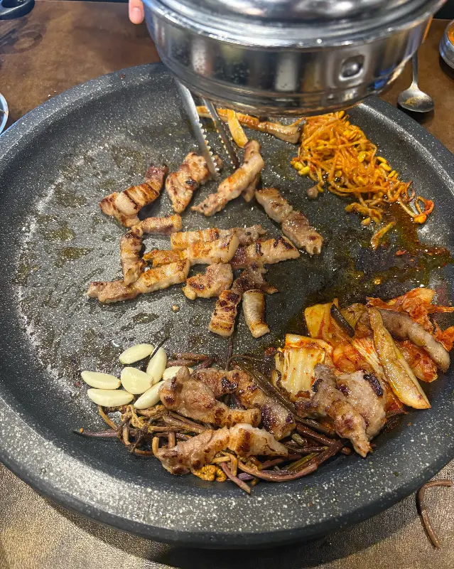 불판 위에 구워지고 있는 삼겹살과 김치