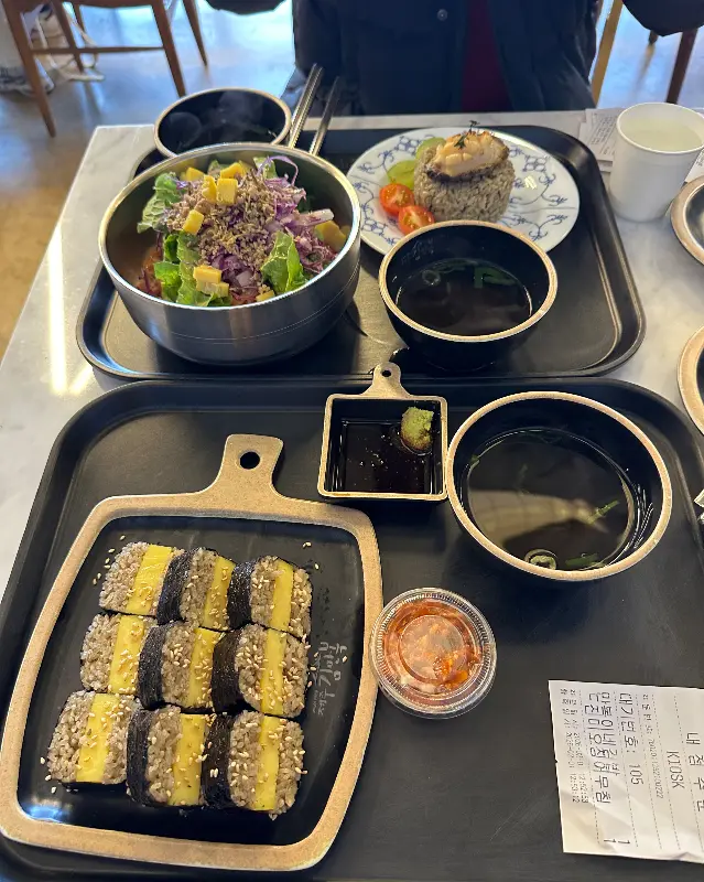 김밥, 샐러드, 전복주먹밥이 함께 담겨져 있는 한 상 차림