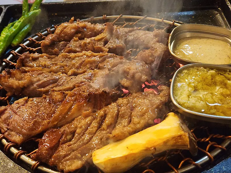 숯불 위에 구워진 마농살과 마늘 크림 소스