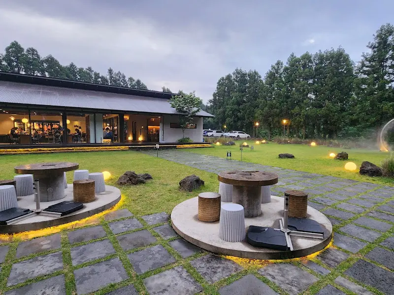 야외 테이블과 조명이 조화롭게 어우러진 보름숲의 야경