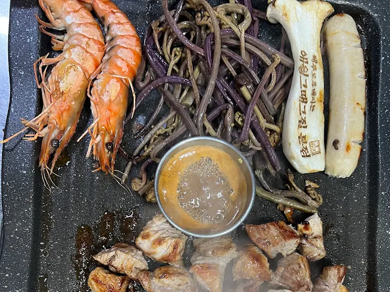 숯불 위에서 구워지는 흑돼지, 새우, 고사리