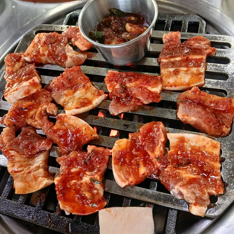 불판 위에서 맛있게 익어가는 양념 삼겹살