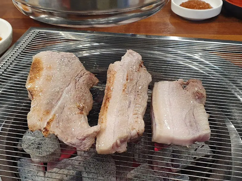 숯불 위에서 노릇하게 익어가는 흑돼지 오겹살