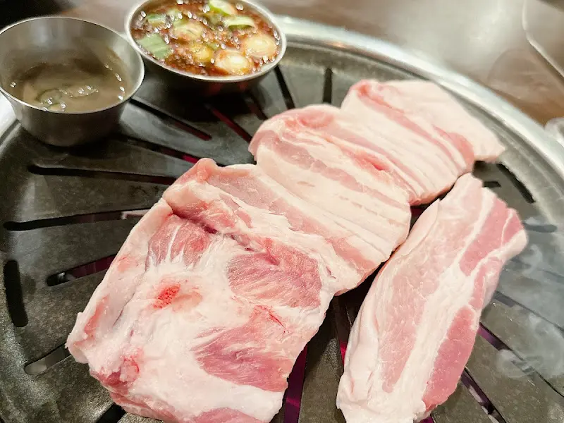 불판 위에 올려진 흑돼지 오겹살