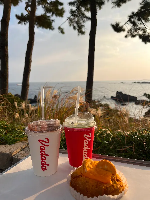 바다를 배경으로 놓인 커피와 빵