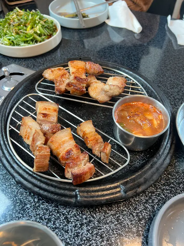 잘 익은 고기를 멜젓에 찍어먹는 모습