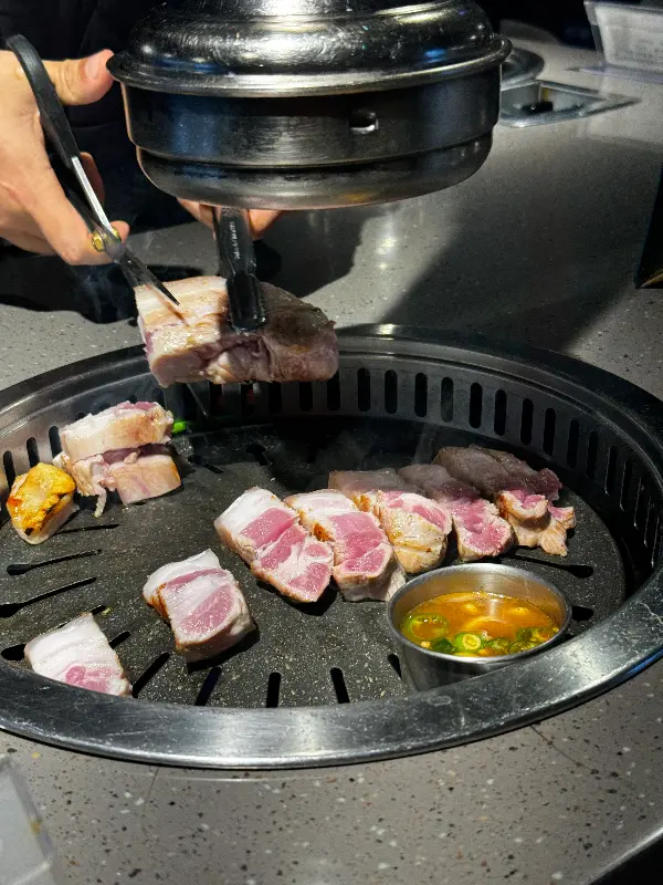 직원분이 흑돼지 오겹살을 먹기 좋게 잘라주는 모습