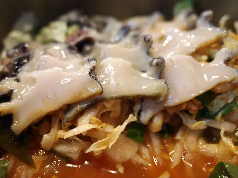 신선한 뿔소라가 듬뿍 들어간 뿔소라 비빔밥의 클로즈업 사진