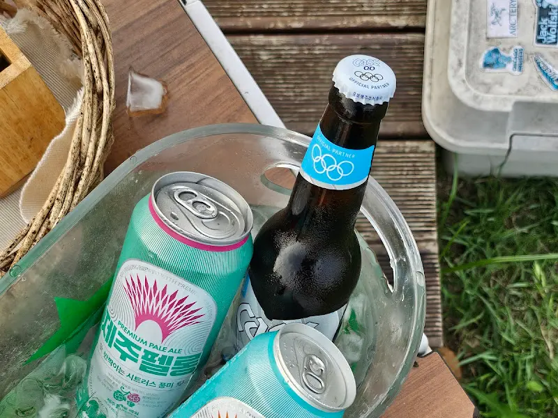 얼음이 가득 담긴 통에 제주 맥주 캔과 병맥주가 들어있다.