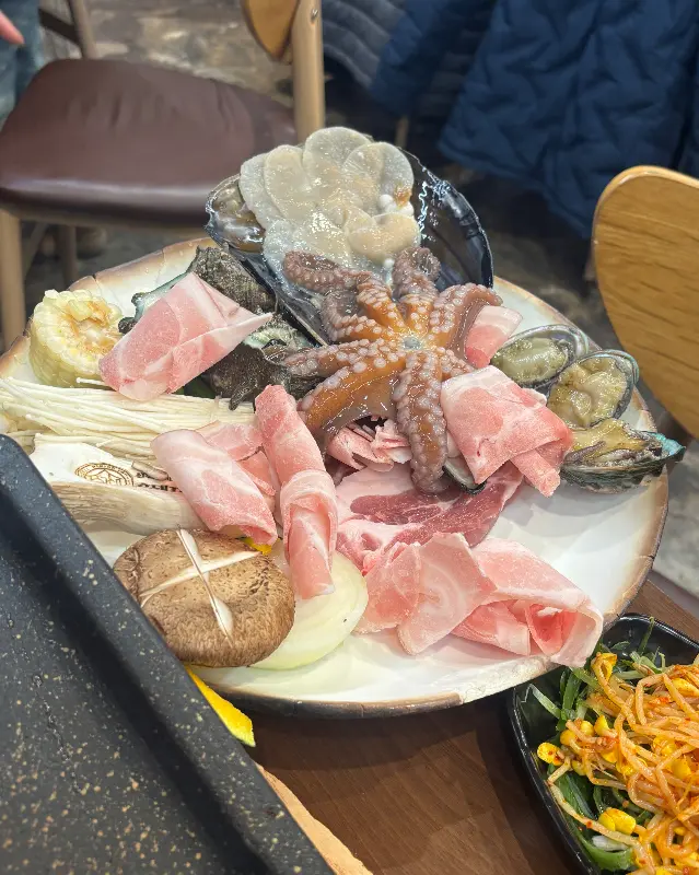 흑돼지, 해산물, 채소가 푸짐하게 담긴 삼합 한 상