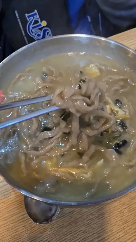 보말칼국수의 면발을 들어올리는 모습