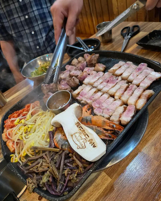 불판 위에서 지글지글 익어가는 흑돼지 오겹살과 목살