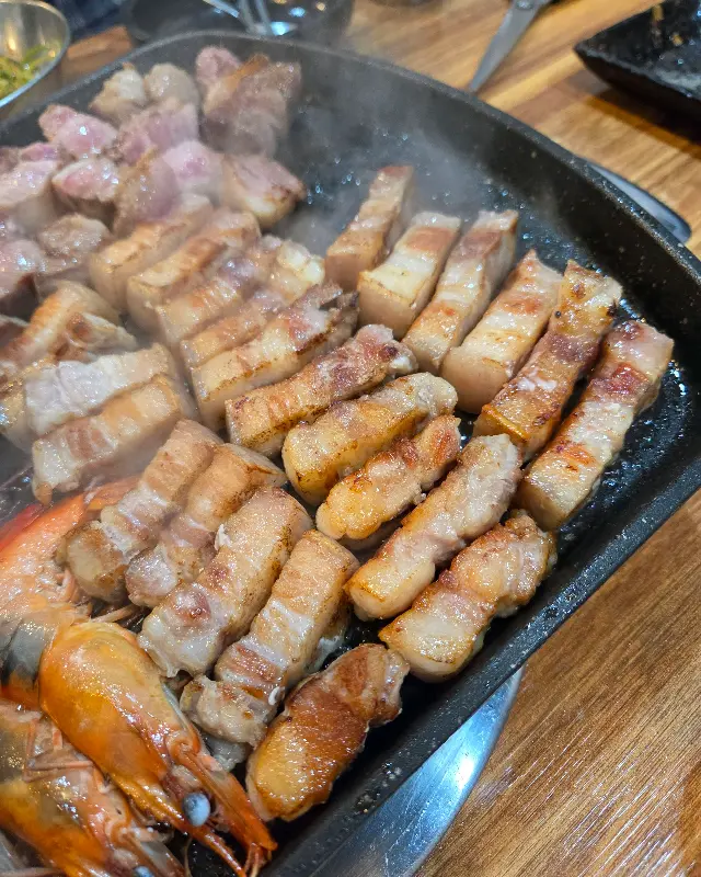 노릇노릇하게 구워진 흑돼지 오겹살과 목살의 단면