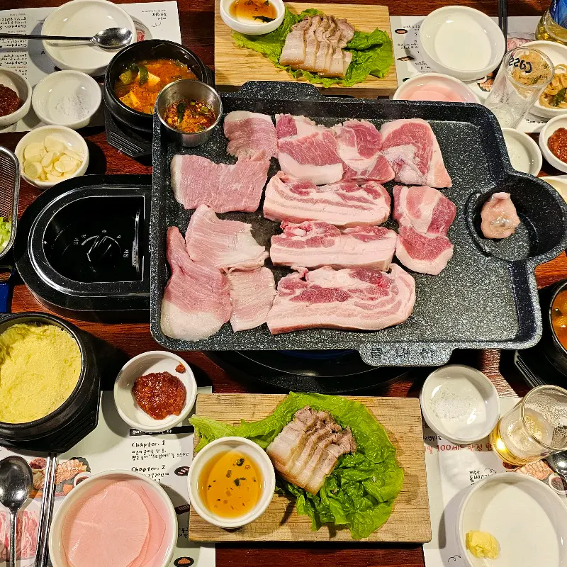 흑돼지 오겹살, 돔베고기, 찌개, 계란찜, 밑반찬으로 가득한 푸짐한 한 상 차림