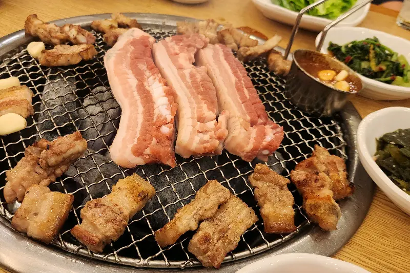 노릇하게 구워진 흑돼지 삼겹살과 멜젓