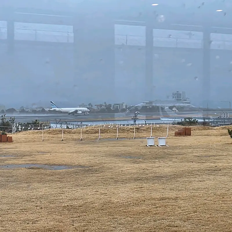 창밖으로 보이는 활주로와 이륙하는 비행기