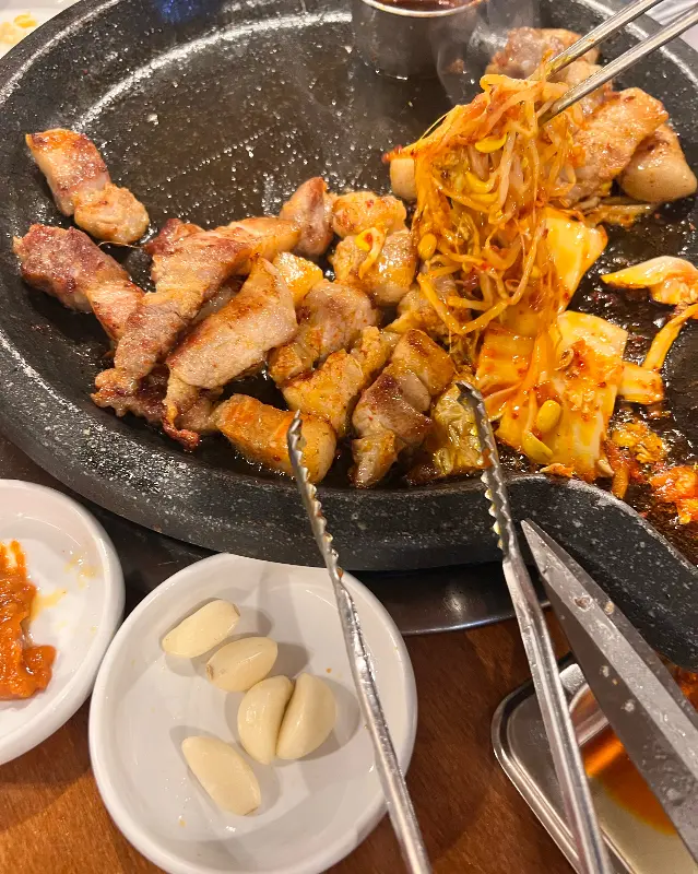 노릇하게 익은 흑돼지 삼겹살과 김치, 콩나물의 환상적인 조합