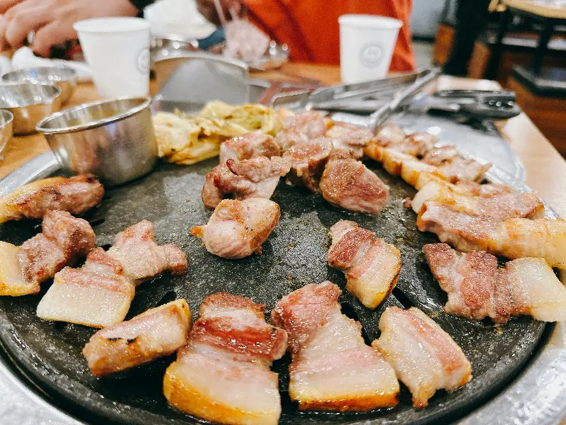 잘 구워진 흑돼지 근고기가 불판 위에 가득 놓여있는 모습
