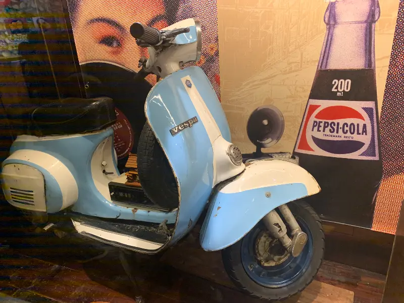 카페 외부에 놓인 파란색 스쿠터