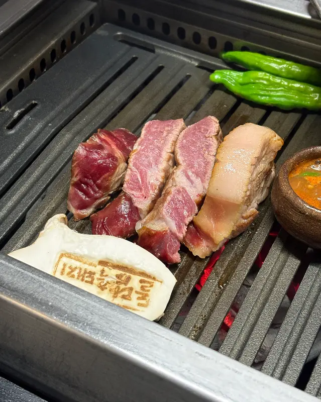 불판 위에서 익어가는 흑돼지 근고기