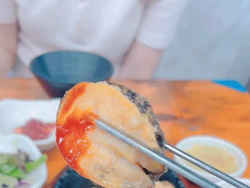 전복구이를 소스에 찍어 먹는 모습