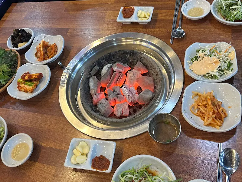 숯불 화로와 테이블 가득한 밑반찬