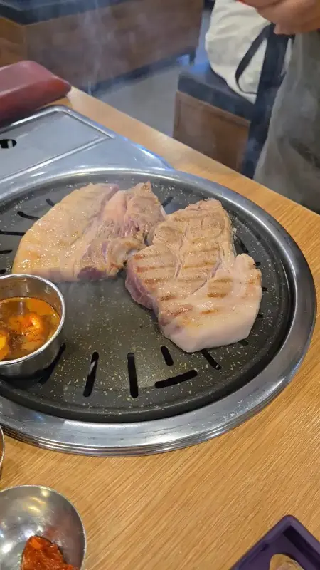 불판 위에서 익어가는 흑돼지 근고기의 영상 썸네일