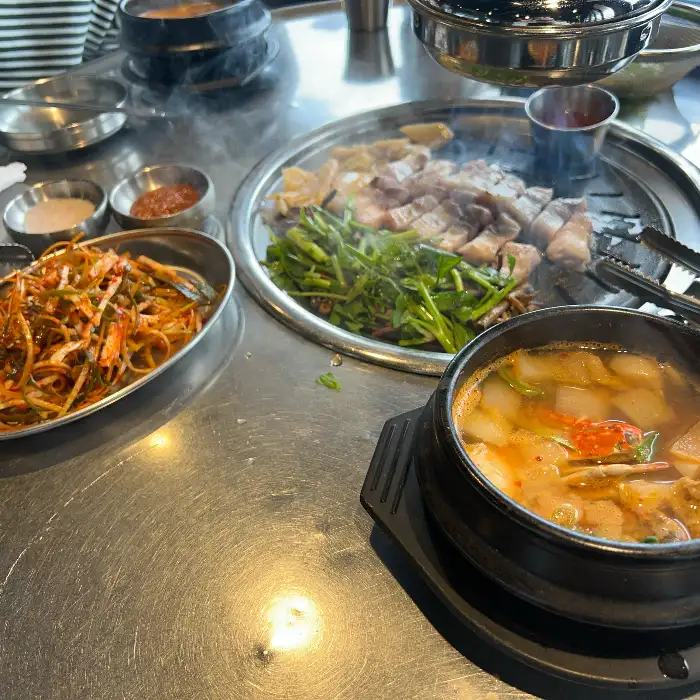 다양한 반찬과 함께 푸짐하게 차려진 흑돼지 구이 한상차림