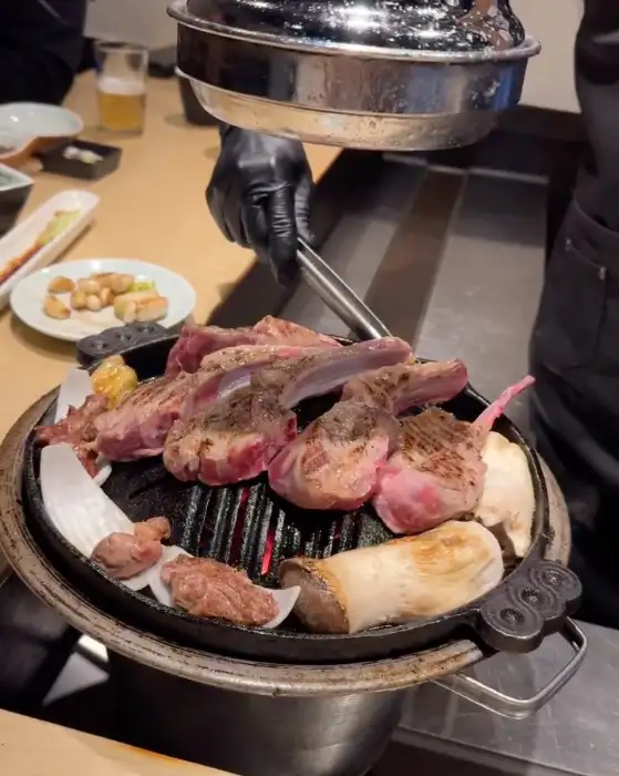 직원이 양갈비를 능숙하게 뒤집으며 굽고 있는 모습