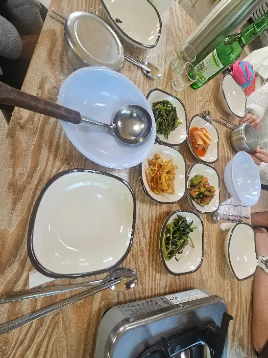 다양한 종류의 밑반찬이 정갈하게 담겨 테이블 위에 놓여 있다.