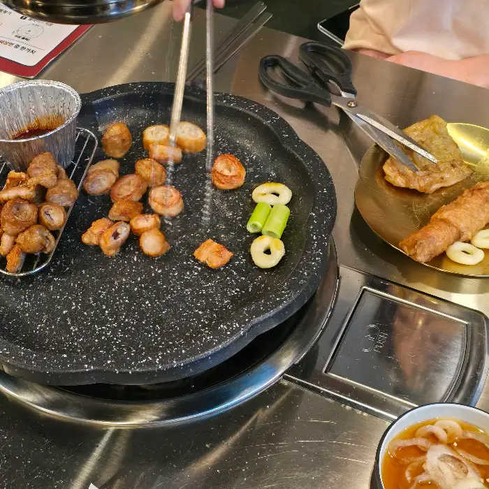 철판 위에서 막창을 뒤집는 집게