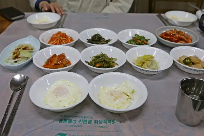 여러 가지 반찬이 담긴 작은 그릇들이 식탁에 놓여 있는 모습