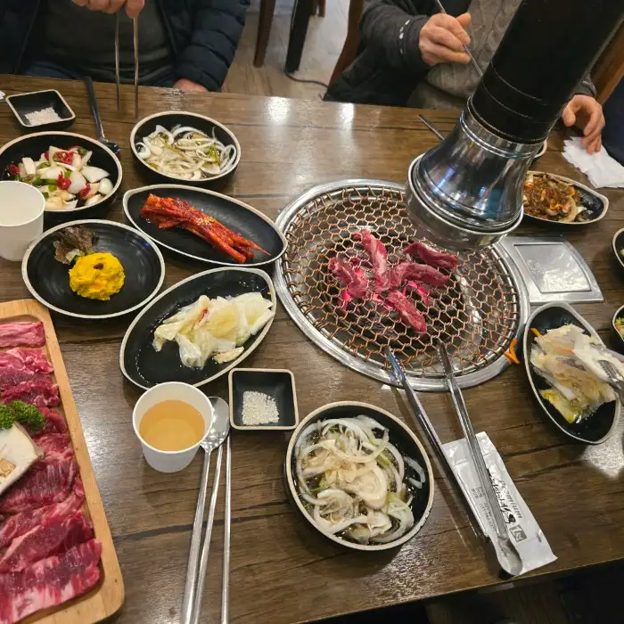 테이블 위 숯불 그릴과 음식들