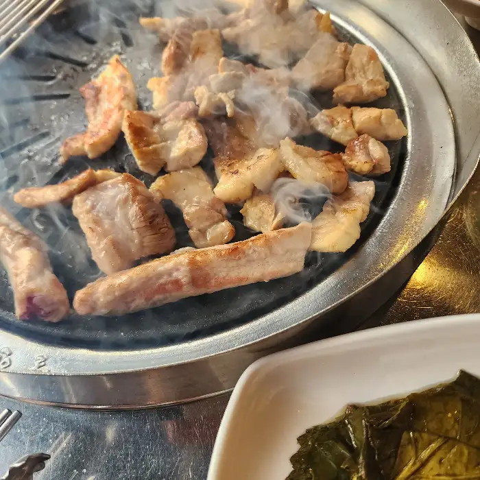 숯불 위에서 구워지는 돼지고기 삼겹살 또는 목살