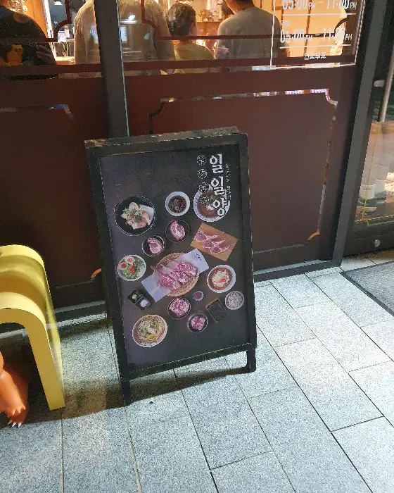가게 앞 안내판에 양갈비와 다양한 메뉴 사진이 진열된 모습